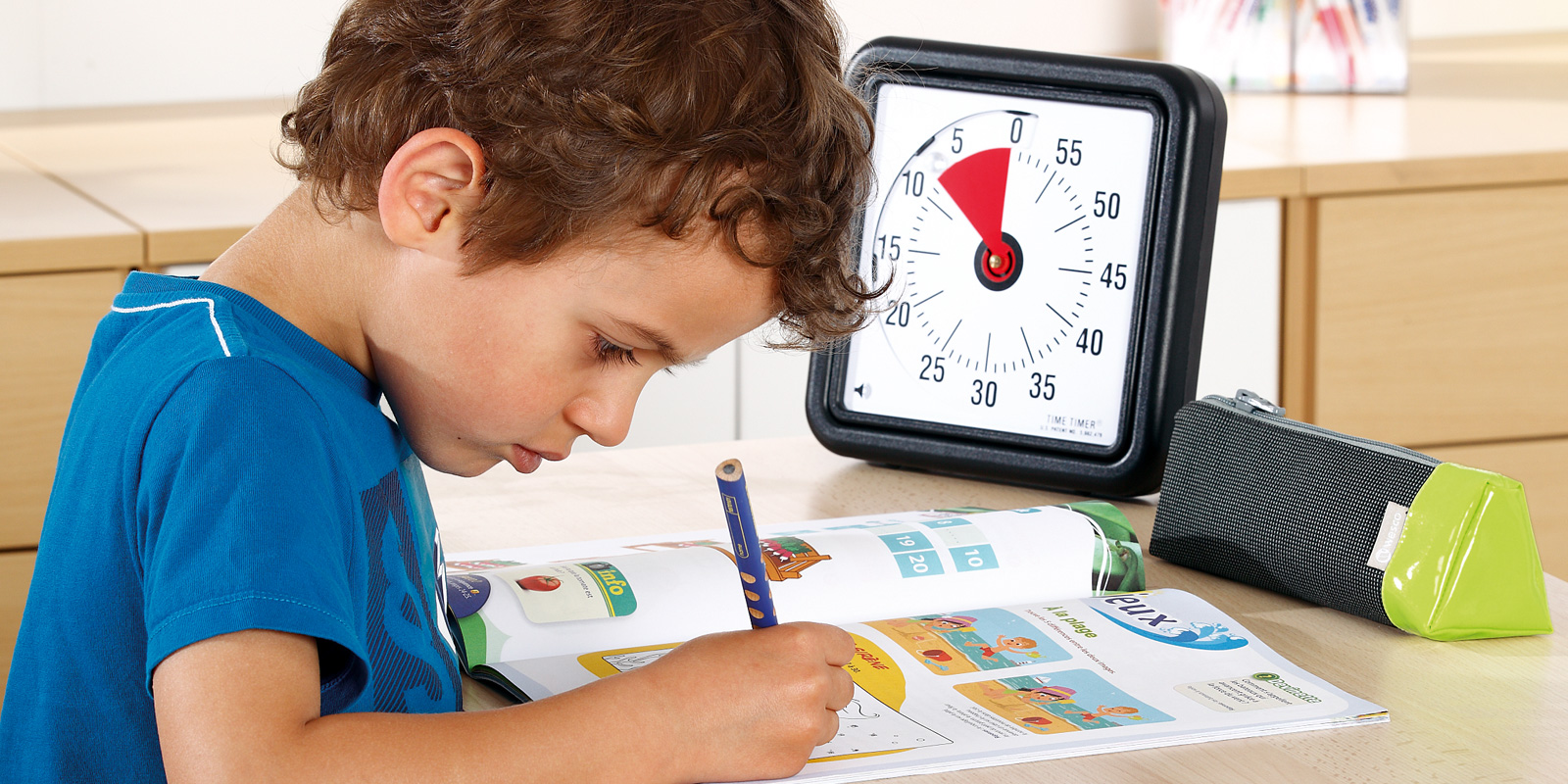 Enfant qui rempli un carnet d'apprentissage avec trousse devant blog wesco
