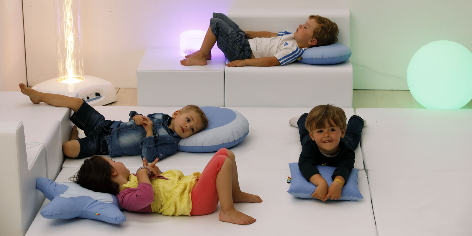 Enfants qui se reposent sur tapis avec colonne à bulles et sphère lumineuse blog Wesco