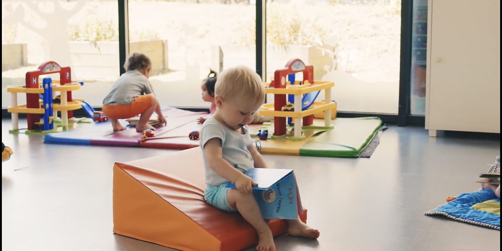bébé qui regarde un livre pour apprendre à l'éveiller blog wesco