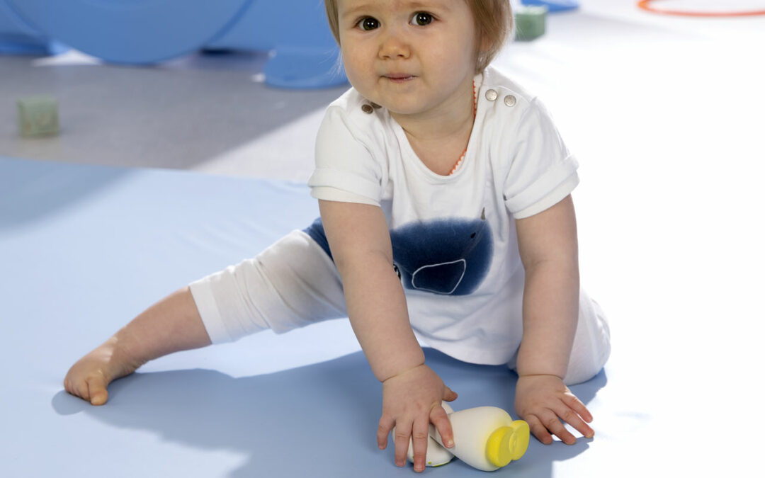 bébé sur tapis assis avec objet dans la main blog wesco