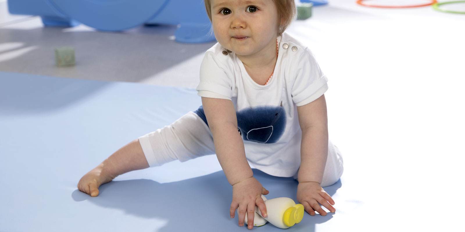 bébé sur tapis assis avec objet dans la main blog wesco