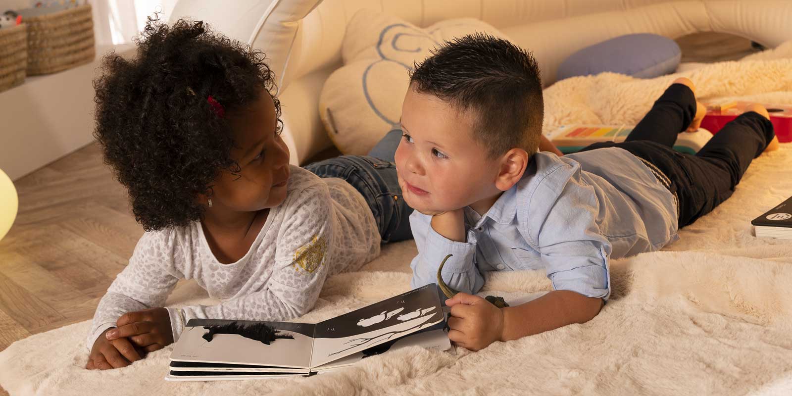 deux enfants sur tapis qui regardent un livre ensemble habiletés sociales blog wesco