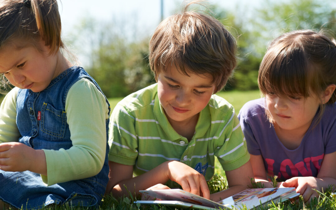 enfants sur l'herbe avec un livre école dehors blog wesco