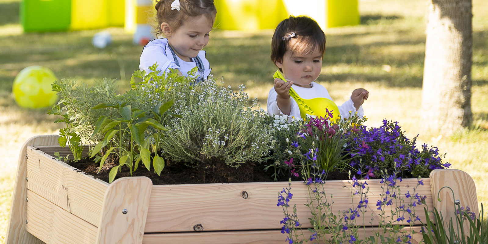 Deux enfants qui jardinent dans un bac en bois à leur hauteur blog wesco