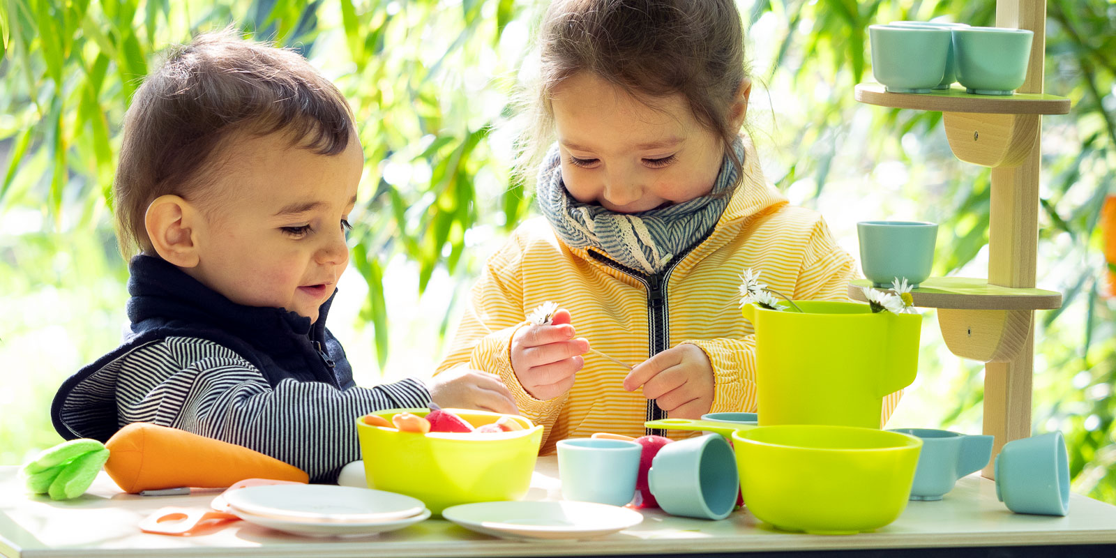 Deux enfants qui jouent avec de la dinette dehors blog wesco