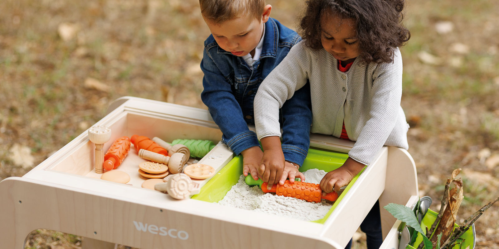 Deux enfants en train de faire un activité sensorielle autour d'une table d'activité blog wesco