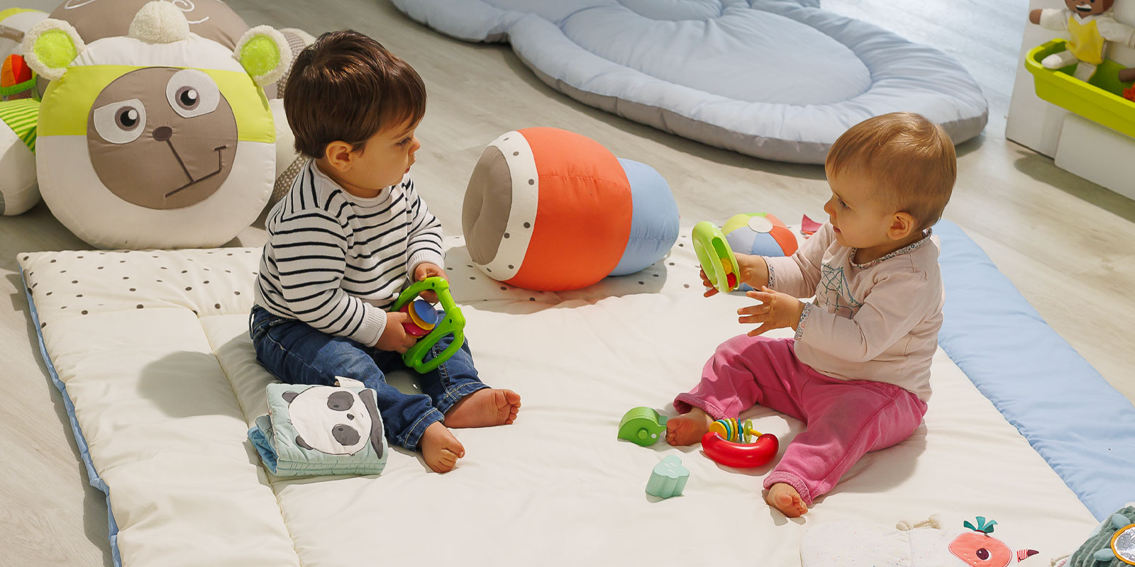 Deux enfants d'un an jouant sur un tapis de motricité chez une assistante maternelle, blog wesco