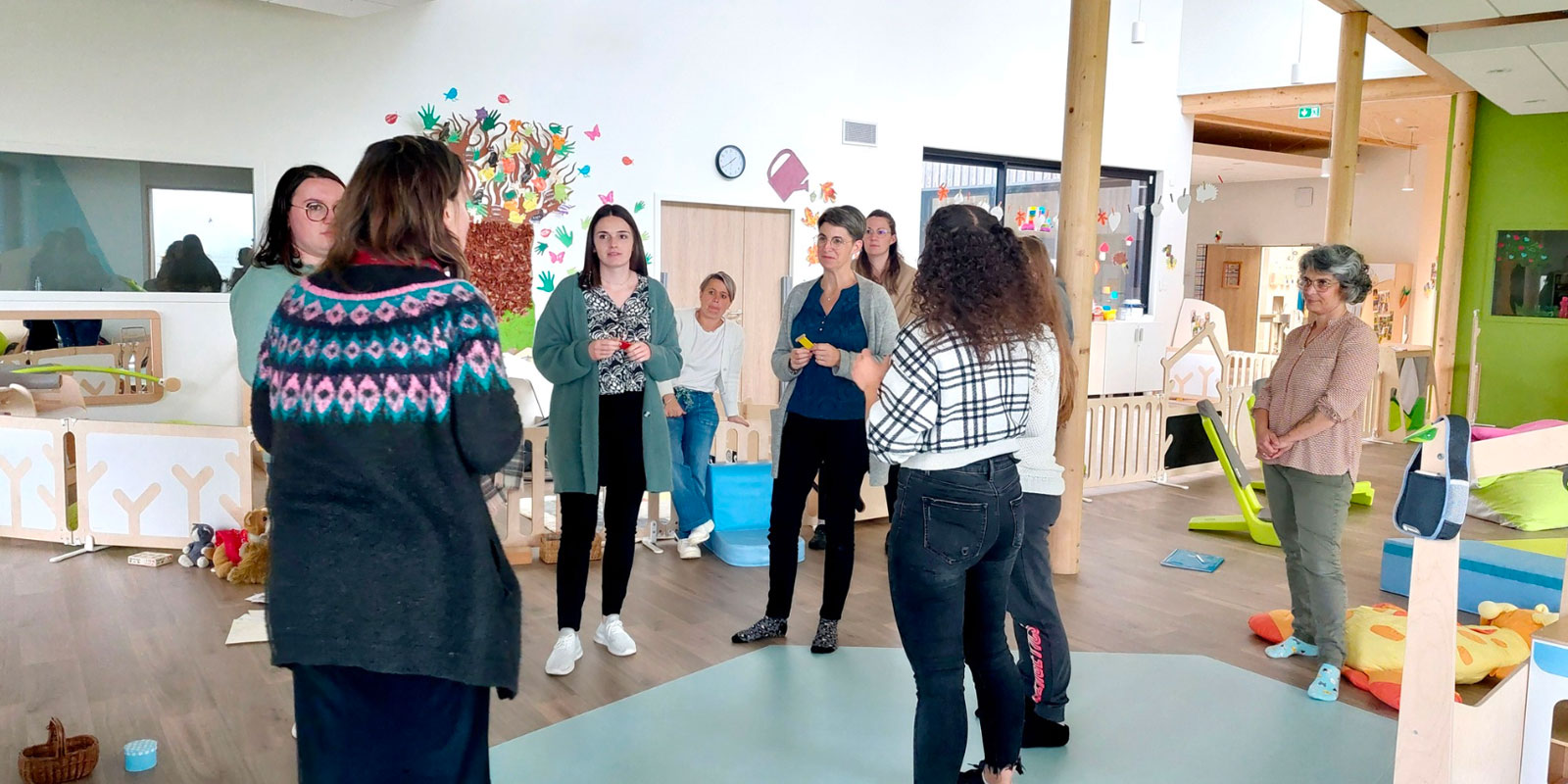 groupe de professionnelles de la petite enfance dans l'espace jeu et motricité d'une crèche avec un temps d'échange sur le projet pédagogique le blog wesco